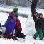 Kinder bauen Schneemänner