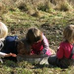 Kinder spielen in der matschigen Wiese